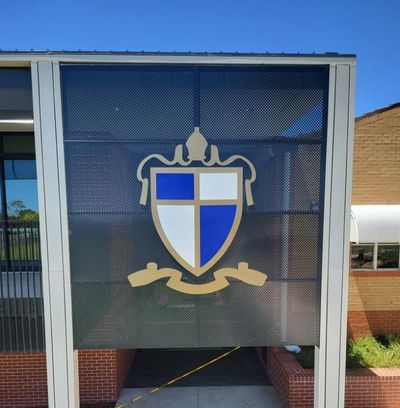 A Shield With a Cross on It is on the Side of a Building — Signworld In Mitchell, ACT