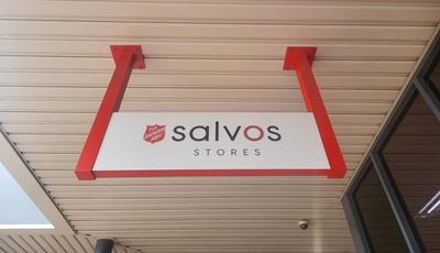 A Salvos Store Sign Hangs From the Ceiling of a Building — Signworld In Mitchell, ACT