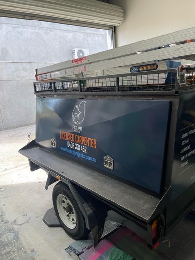 A trailer with a toolbox on top of it is parked in a garage — Signworld In Mitchell, ACT