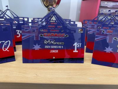 A Bunch of Trophies Are Sitting on a Wooden Table — Signworld In Mitchell, ACT