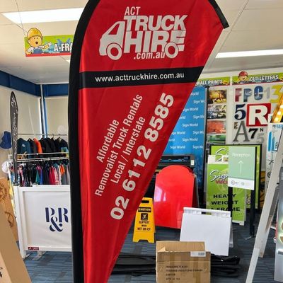 A Red and Black Flag That Says Act Truck Hire — Signworld In Mitchell, ACT