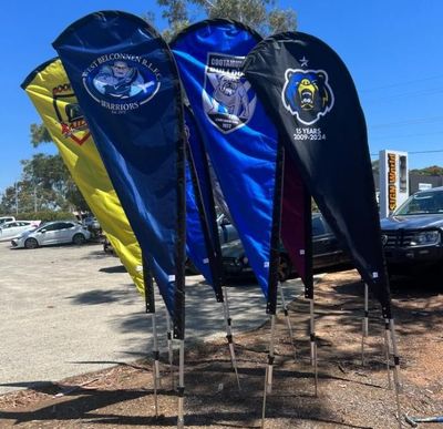 A Bunch of Flags Are Lined Up in a Parking Lot — Signworld In Mitchell, ACT