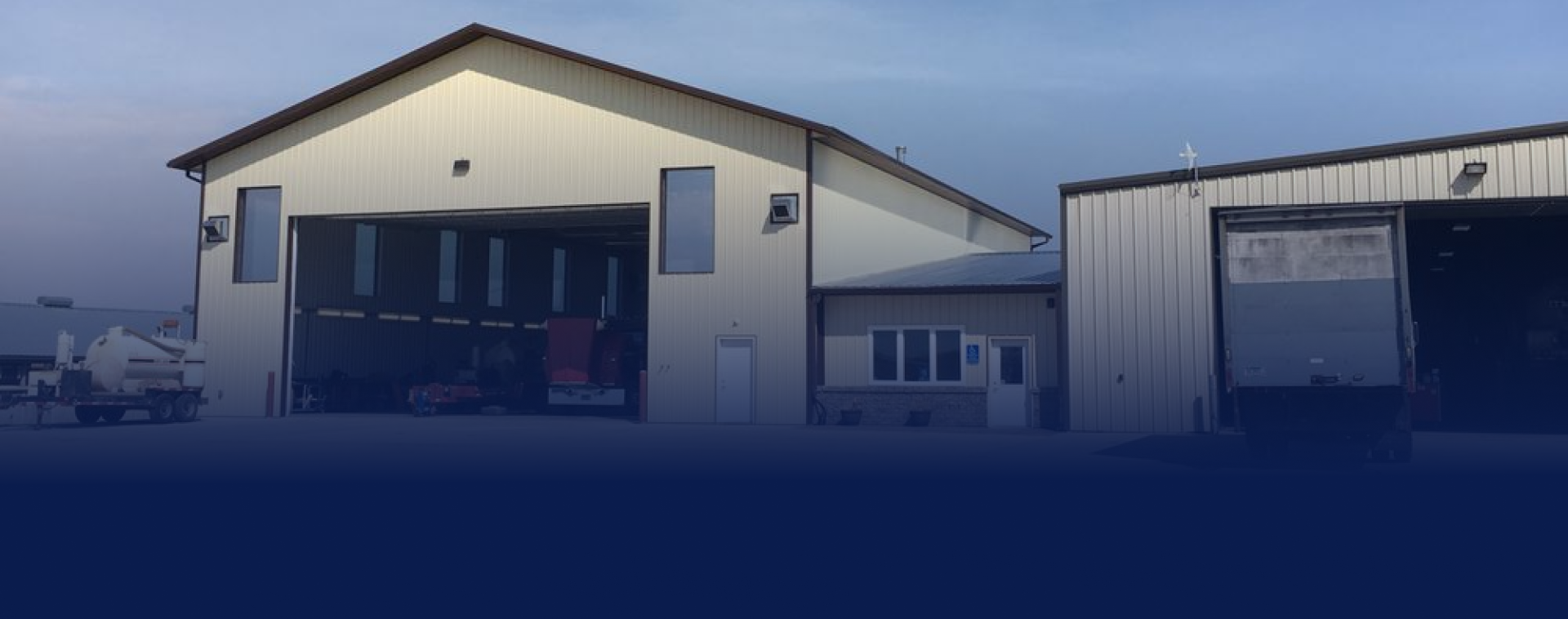 A large white building with a blue sky in the background. | Keck's Repair Inc