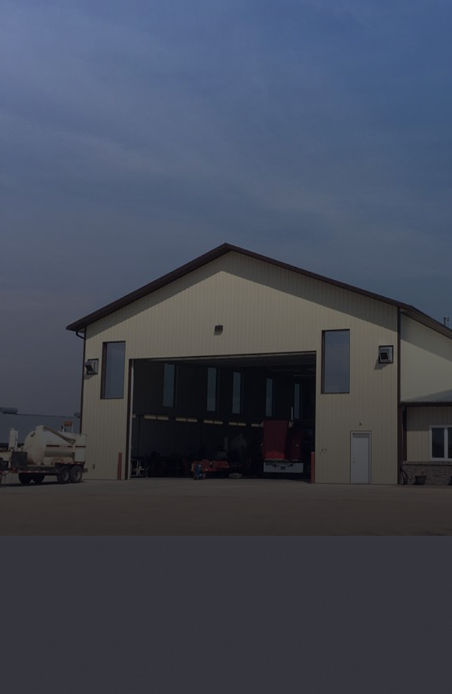 A large building with a lot of windows and a truck parked in front of it | Keck's Repair Inc