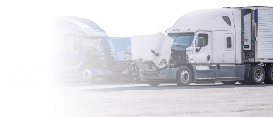 A row of semi trucks are parked in a parking lot. | Keck's Repair Inc