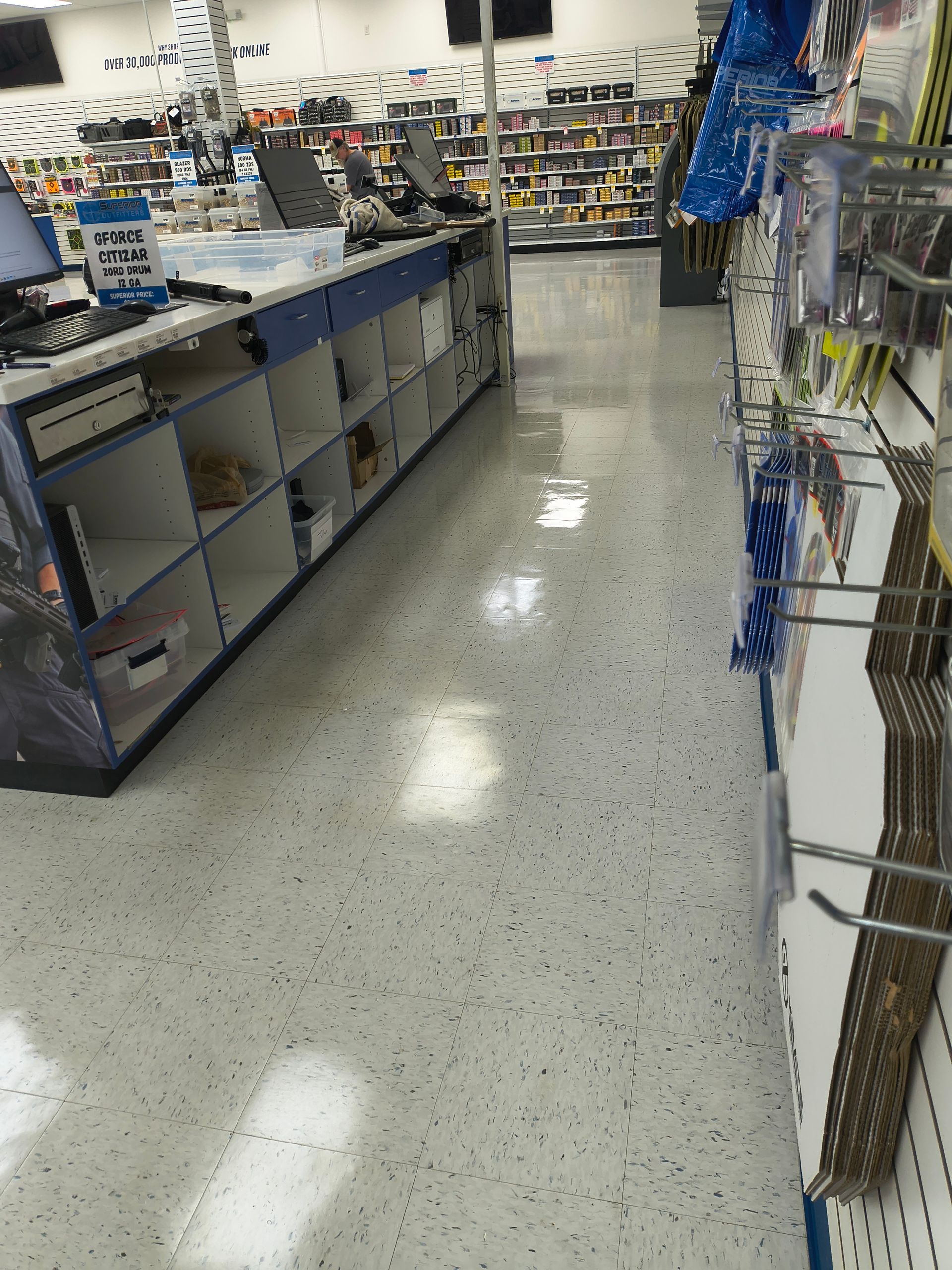 Empty store checkout counter and aisles with product displays.