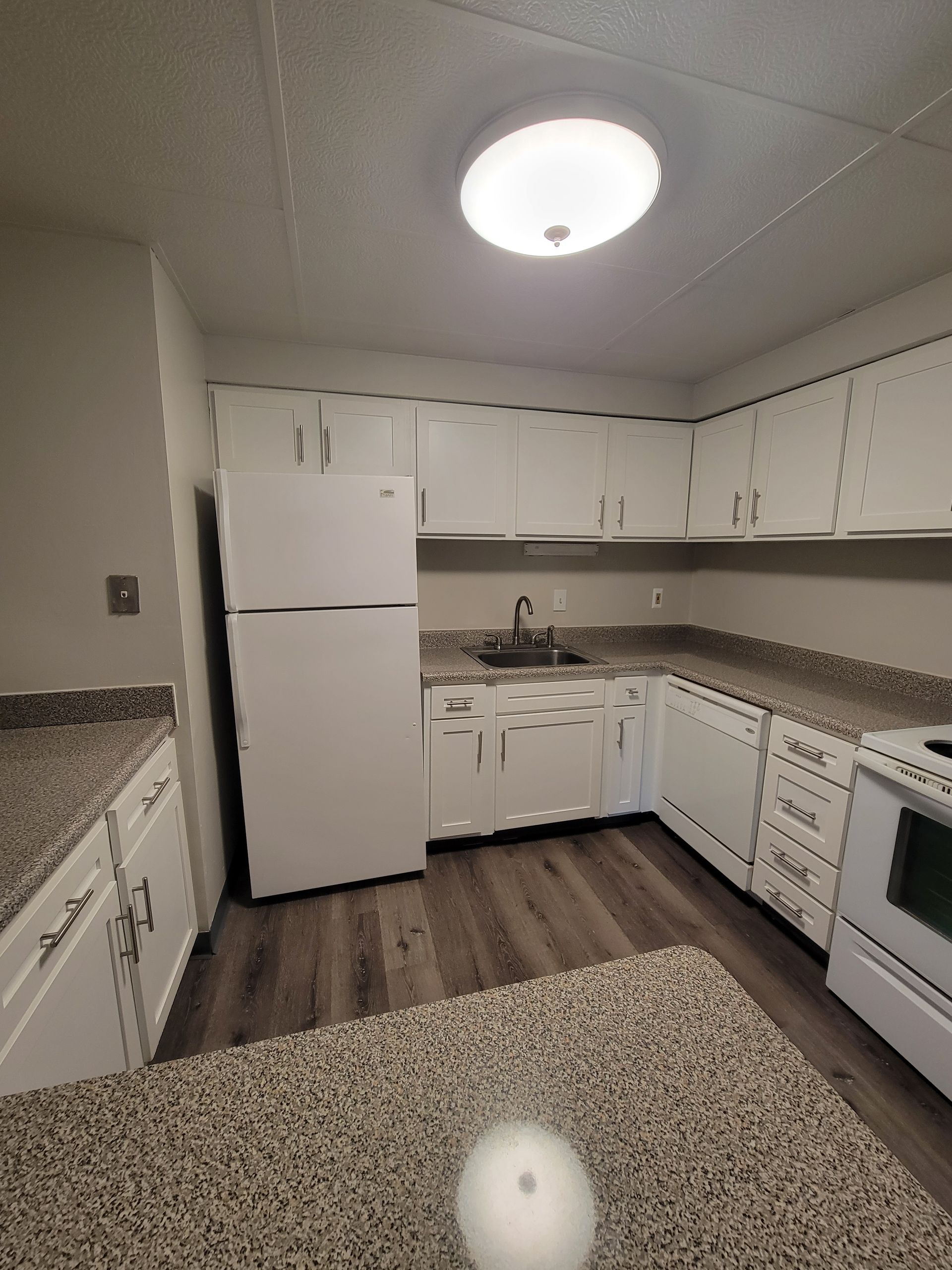 A kitchen with white cabinets and granite counter tops