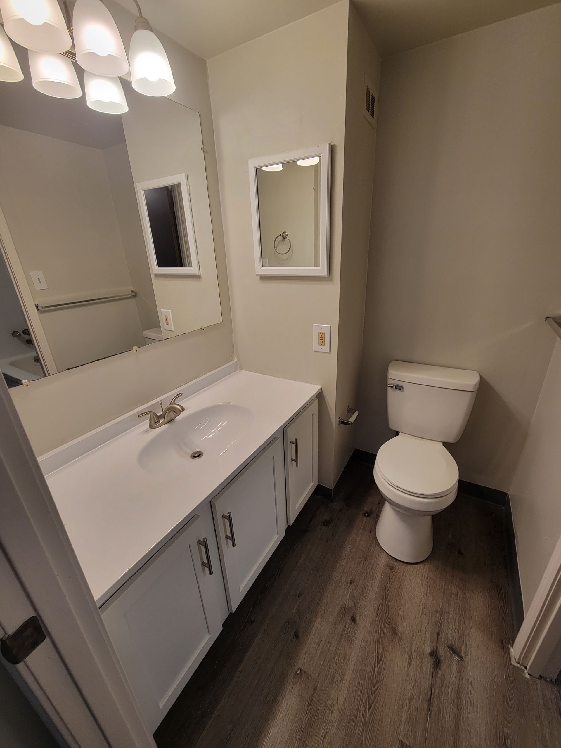 A bathroom with a sink , toilet and mirror.