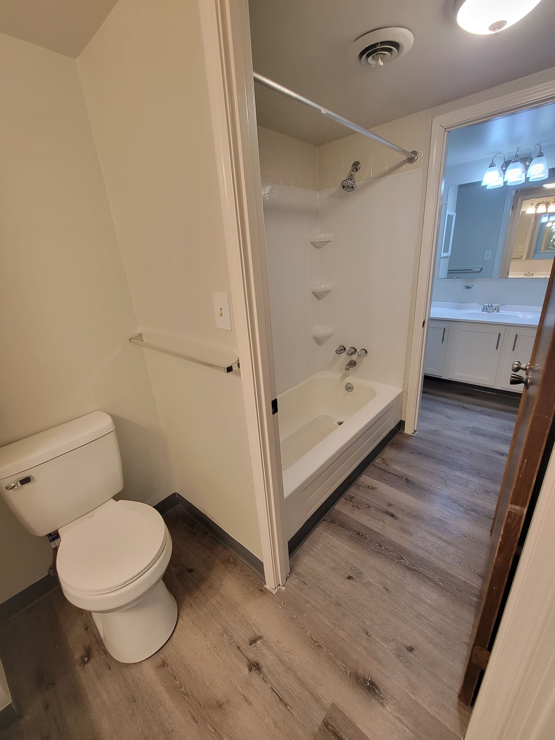 A bathroom with a toilet , bathtub and shower.