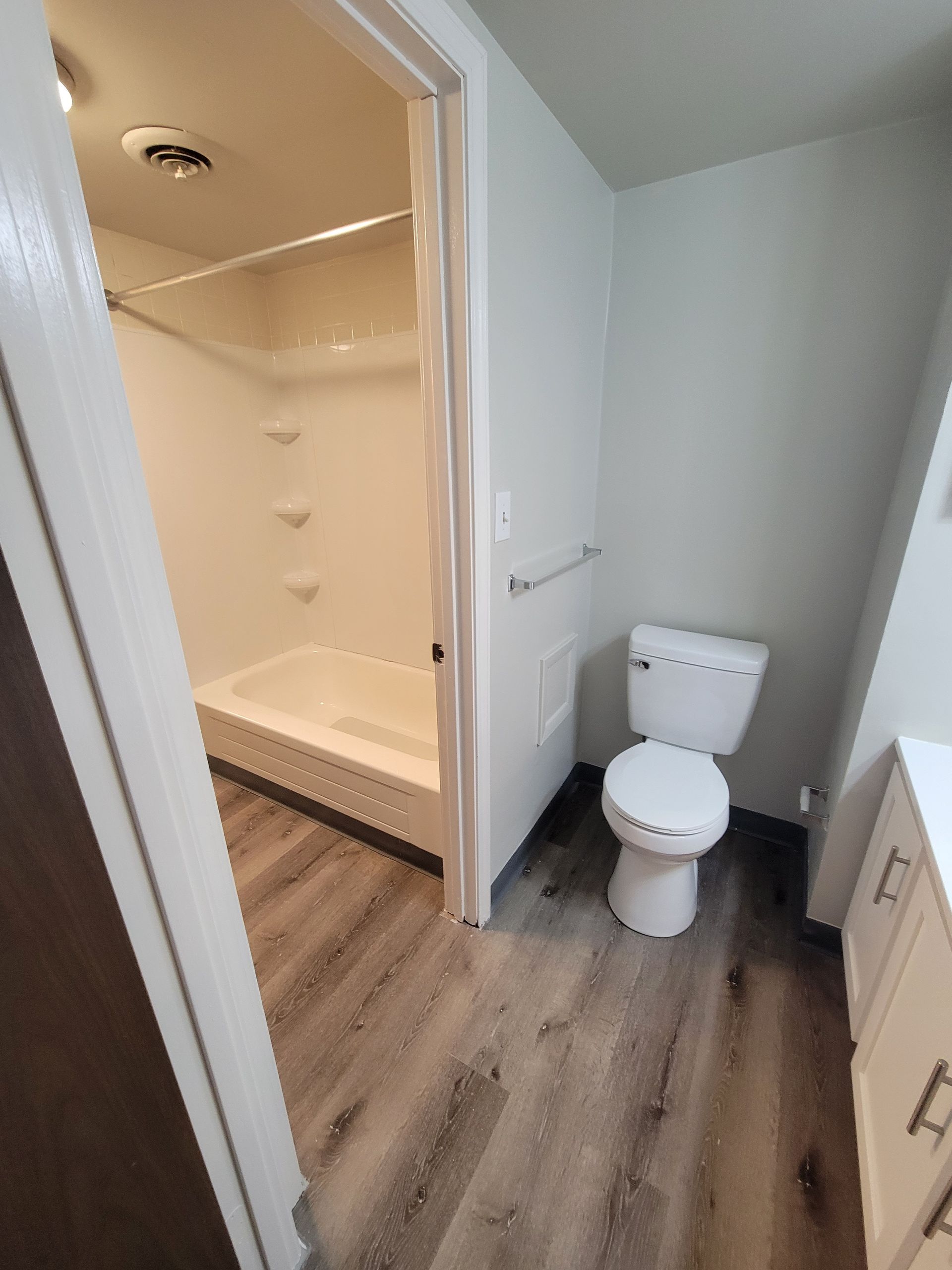 A bathroom with a toilet , sink and shower.