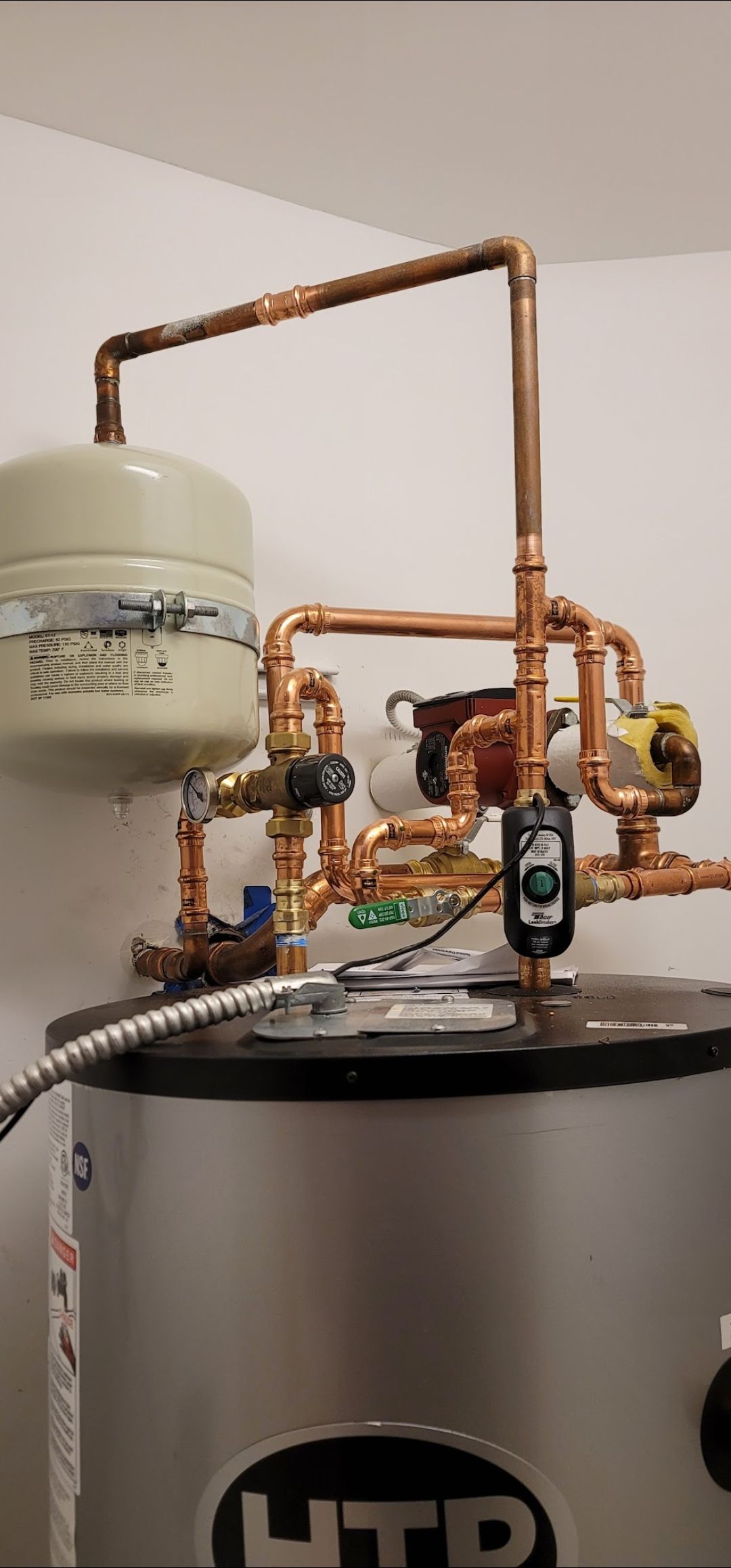 Copper pipes and tank system. Tank has HTP logo and plumbing.