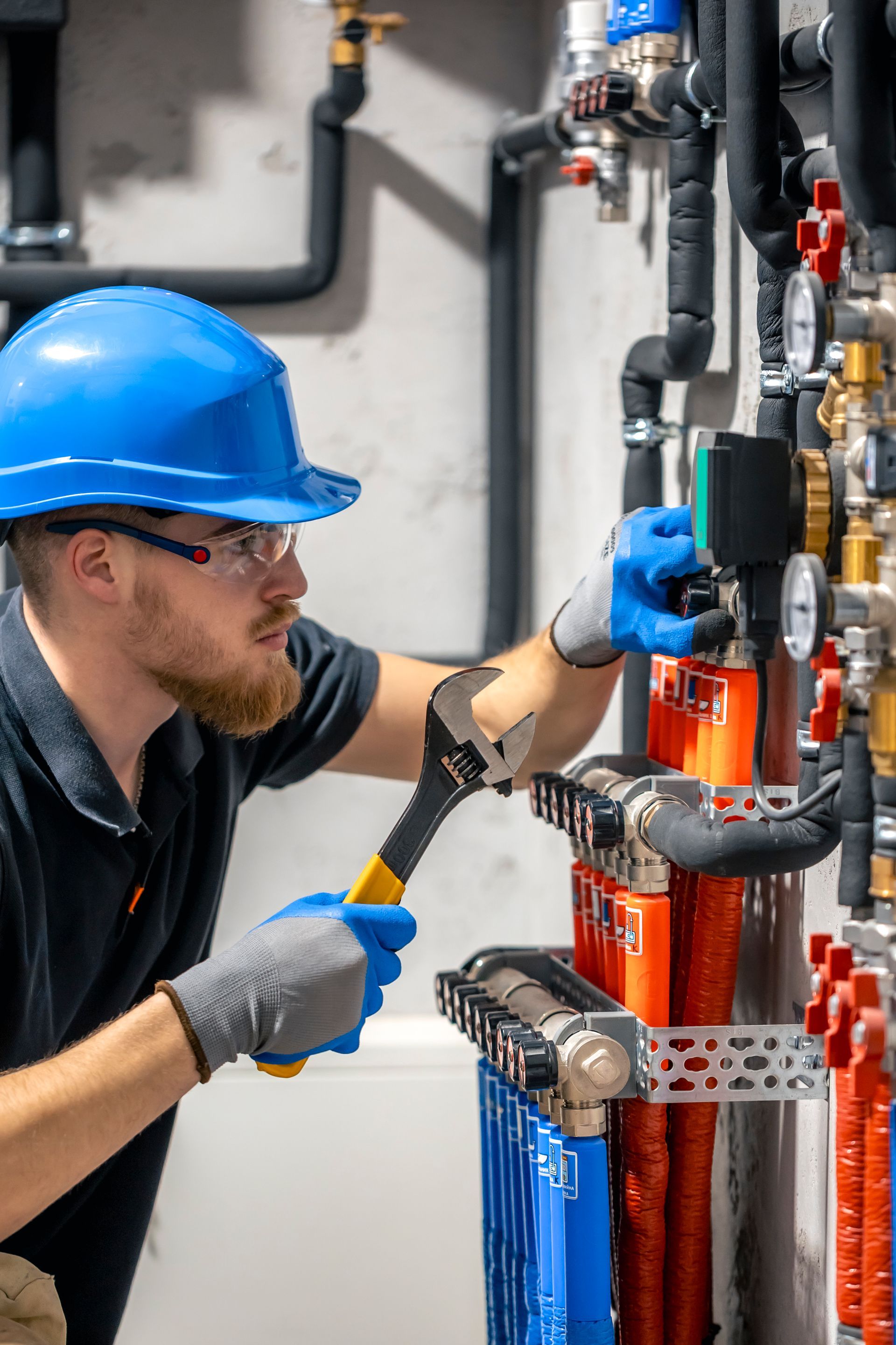 A man is working on a valve in a factory.