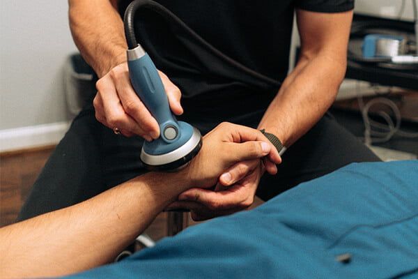 A man getting treated for carpal tunnel syndrome by extracorporeal shockwave therapy in Littleton, CO.