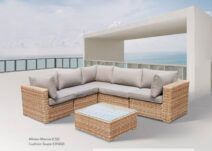 A wicker sectional couch and coffee table on a patio.