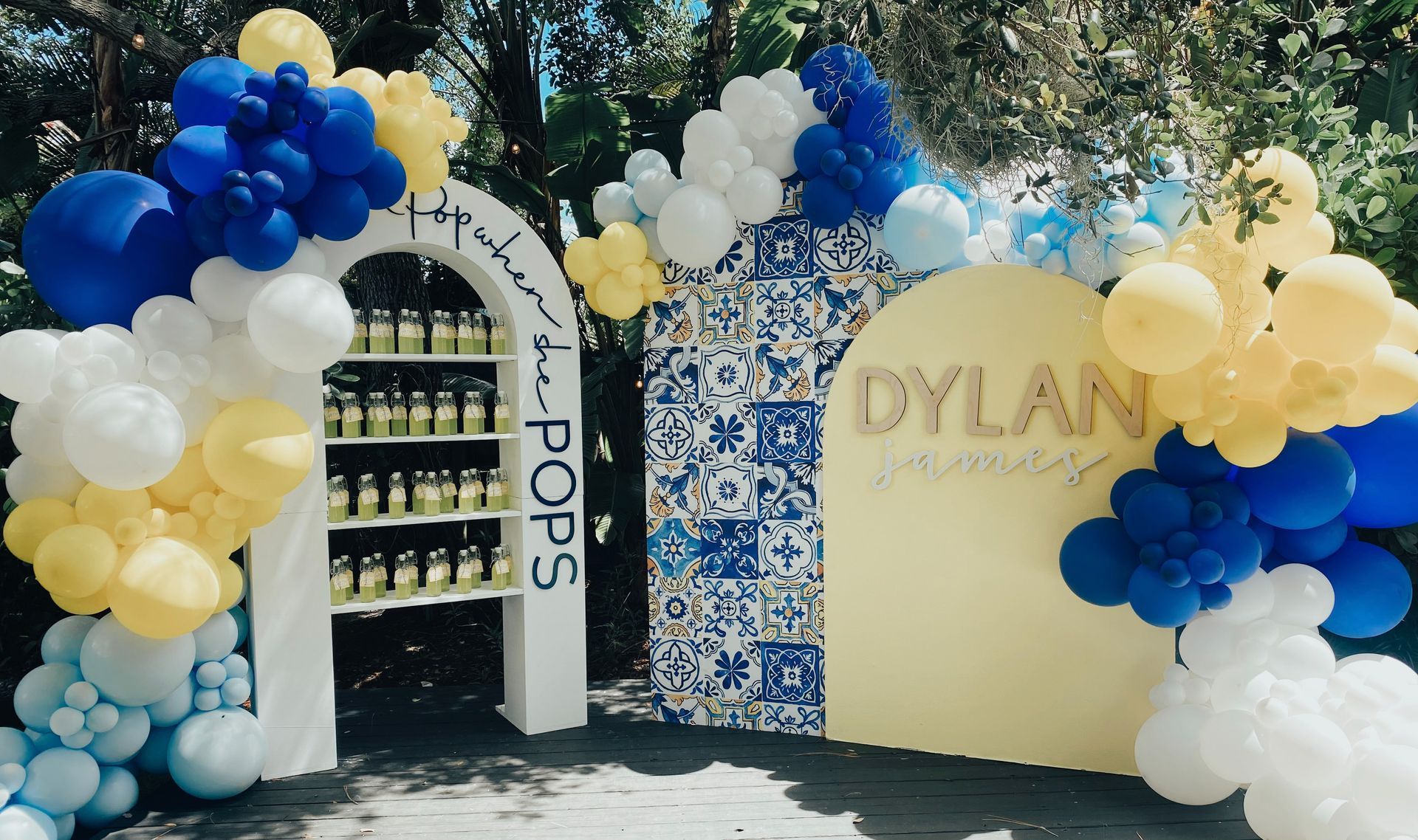 A blue and yellow balloon arch with the name dylan on it