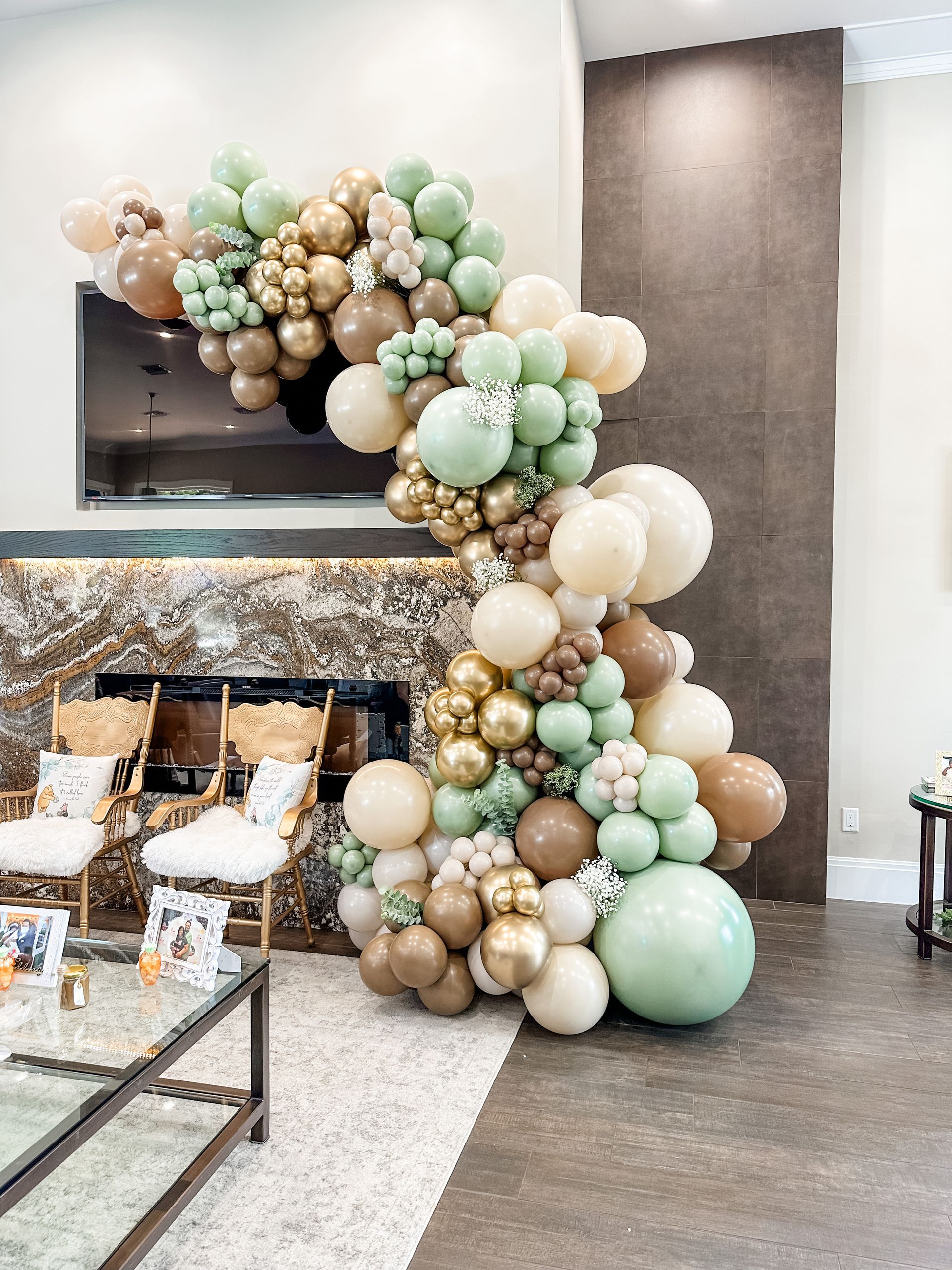 A living room decorated with balloons and chairs and a fireplace.