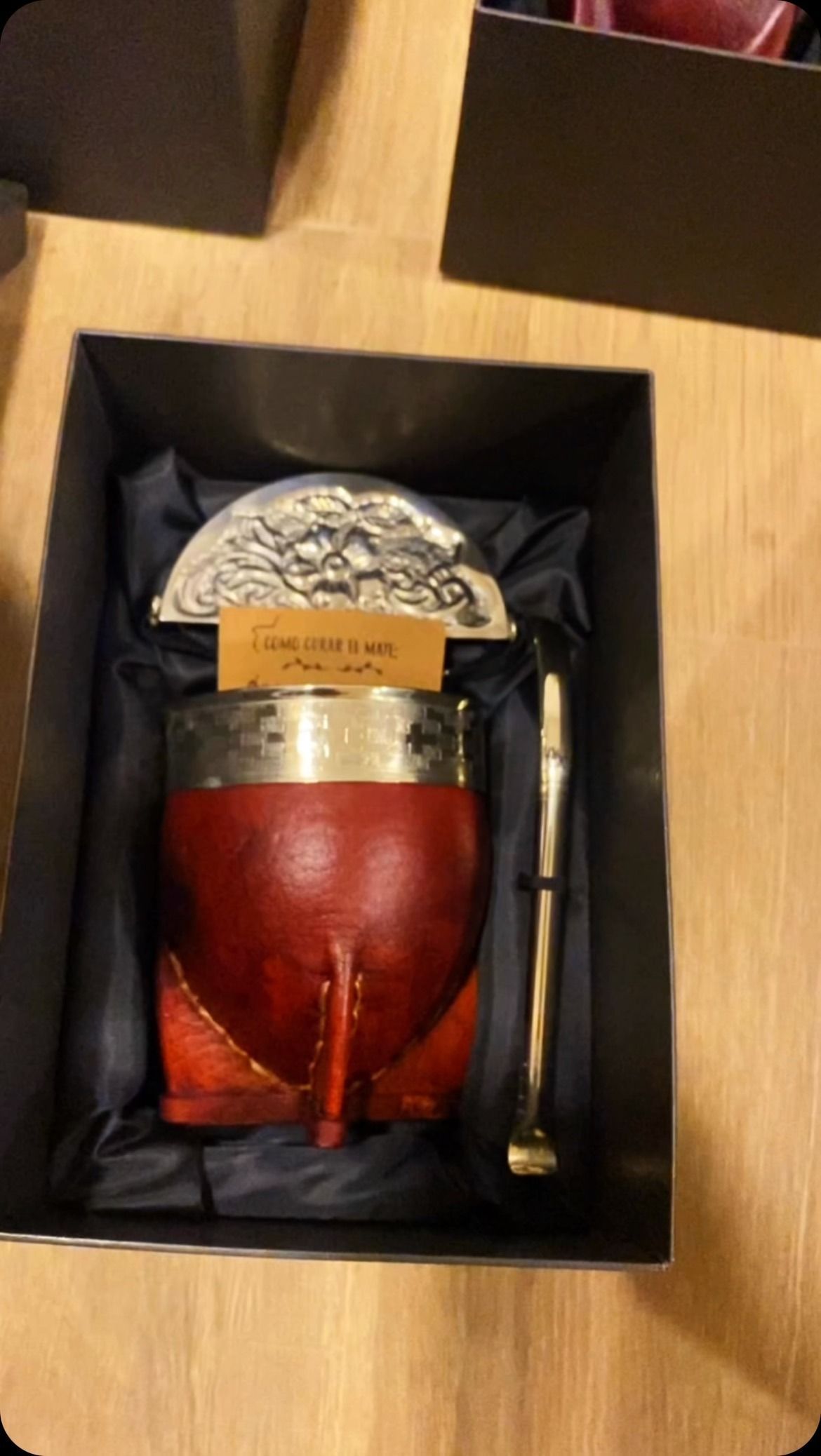 Juego de mate de calabaza roja en caja de regalo negra, con borde plateado, bombilla y tapa de metal.