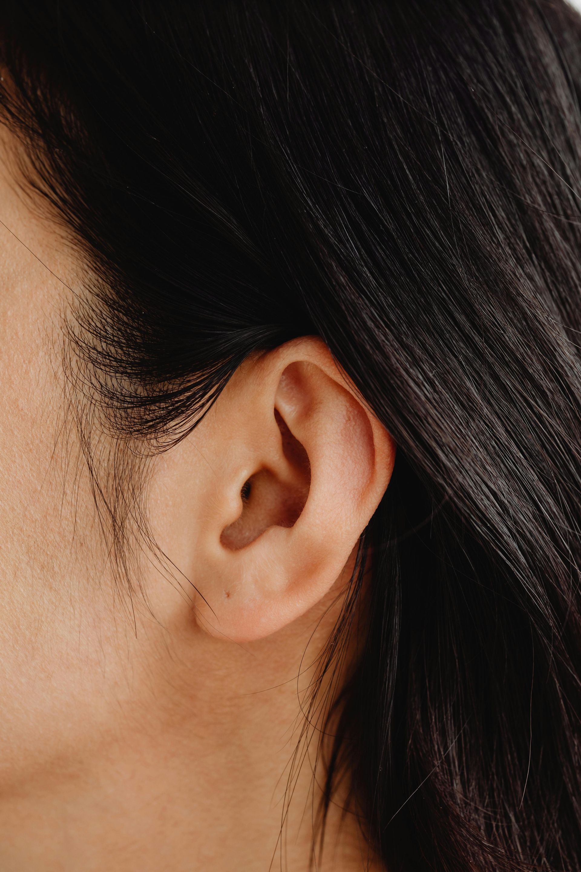 Close-up of a person's ear, with dark hair framing the side of their face — Simply Clear Ear Care in Tinonee, NSW 