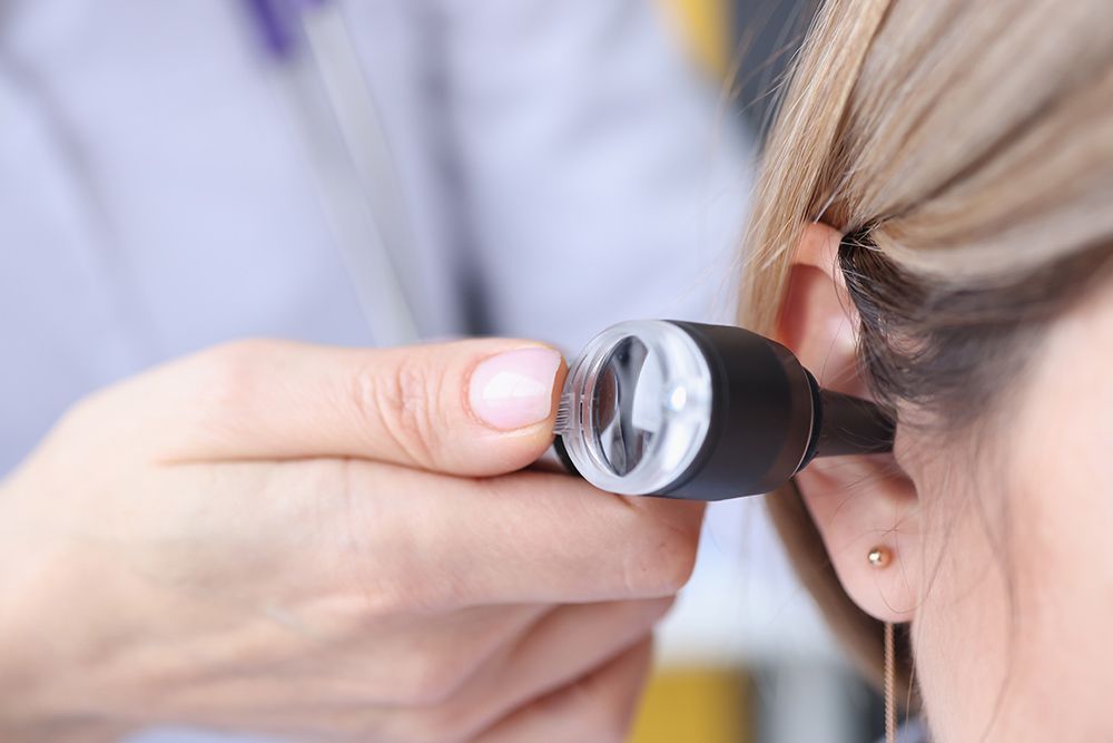 The Doctor's Hand Holds the Device Near the Patient's Ear — Simply Clear Ear Care in Tea Gardens, NSW 