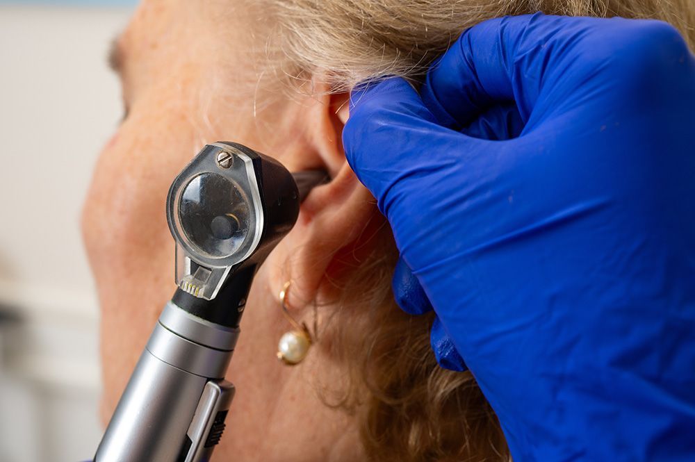 Doctor Examining Patient's Ear with An Otoscope — Simply Clear Ear Care in Tinonee, NSW 