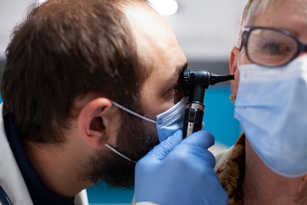 Doctor Examines Patient's Ear with An Otoscope — Simply Clear Ear Care in Tinonee, NSW 