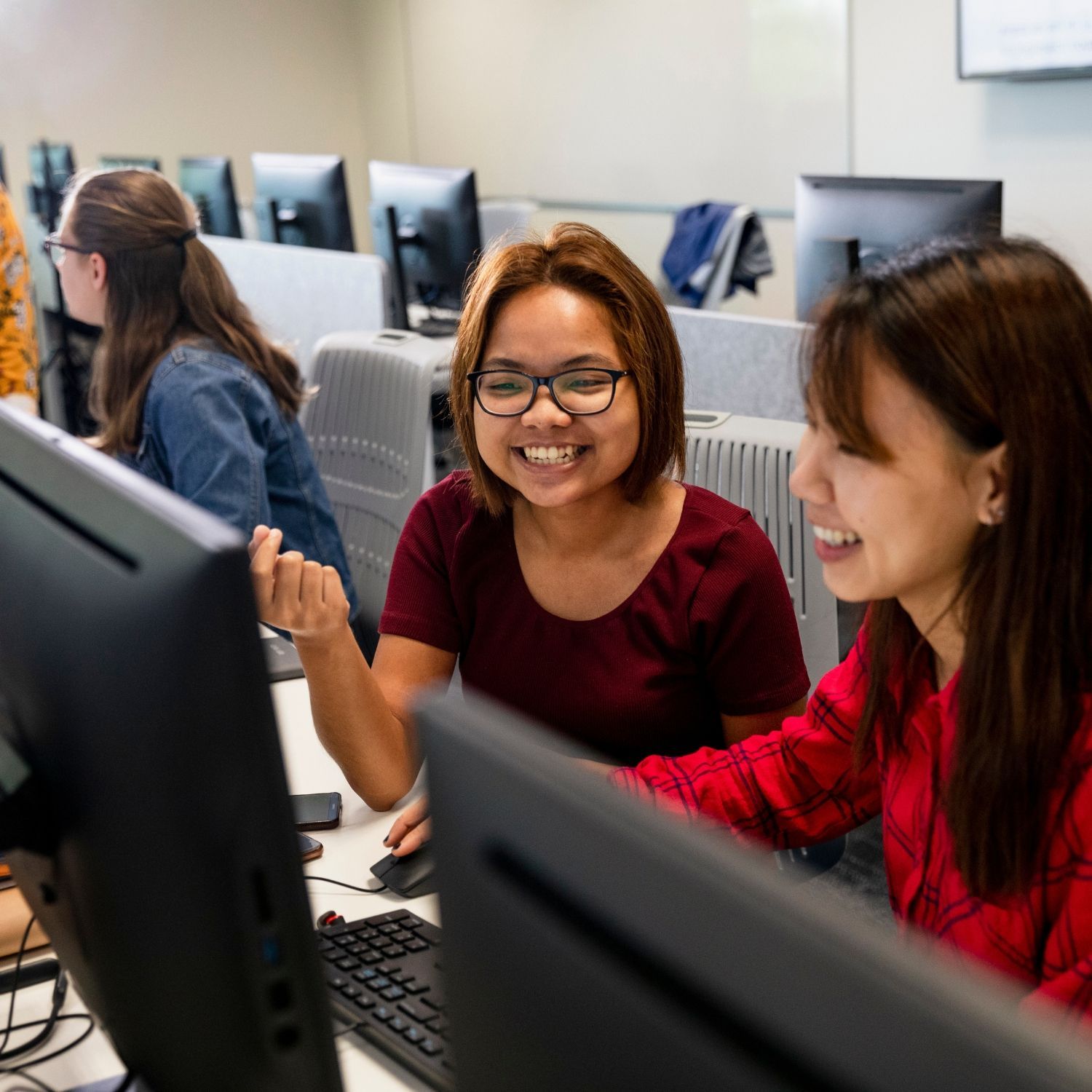 Two women smiling, browsing a computer