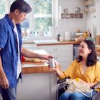 Man handing a drink to a woman in wheelchair