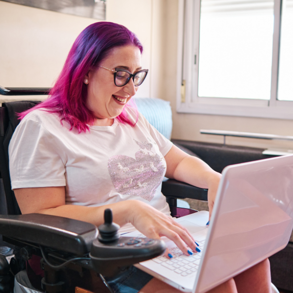 Woman with disability in a wheelchair, with a laptop on her lap