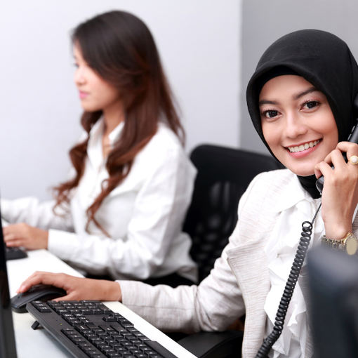 Woman on the phone and sitting in front of computer