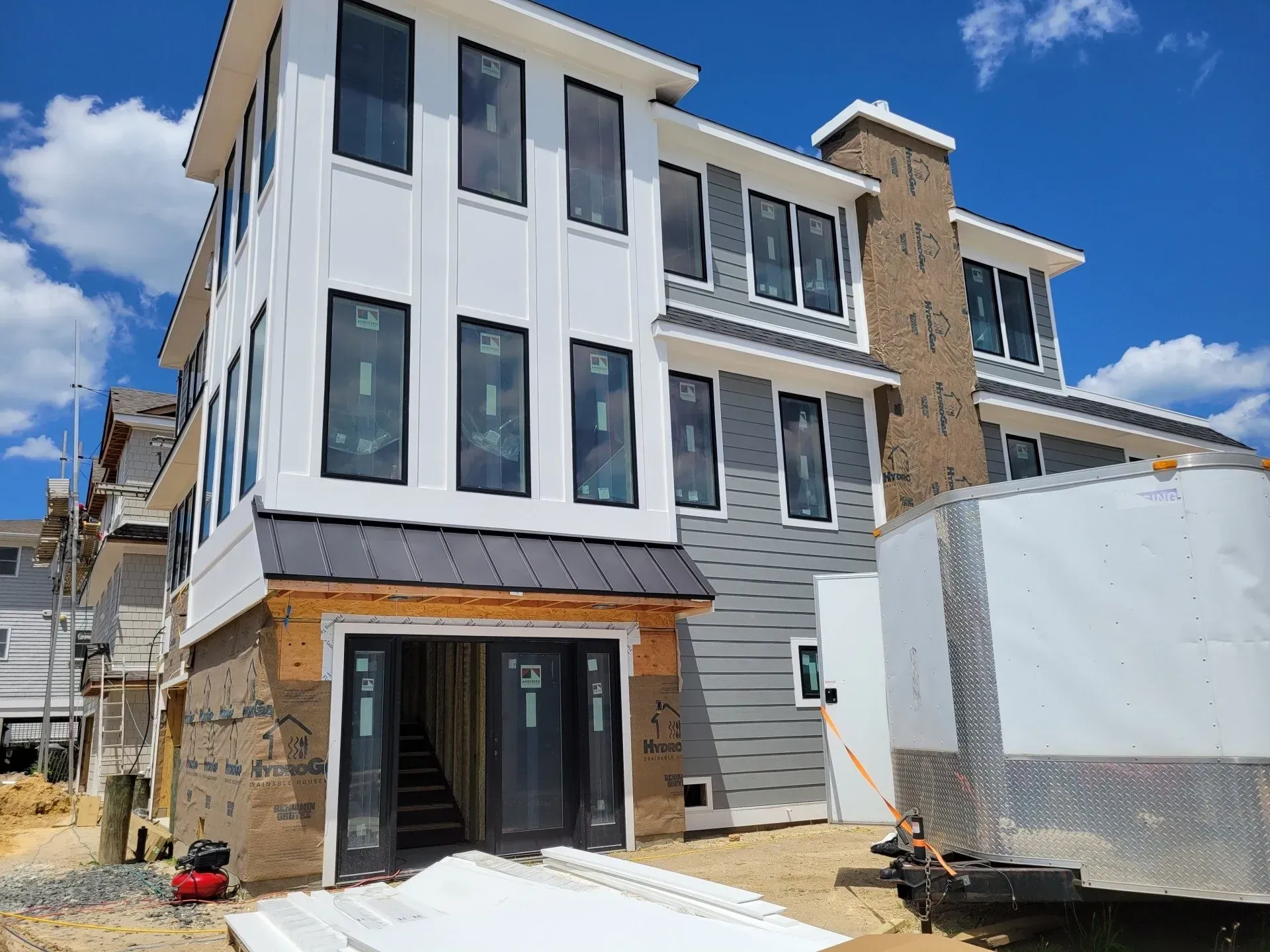 A large white house with a lot of windows is being built.