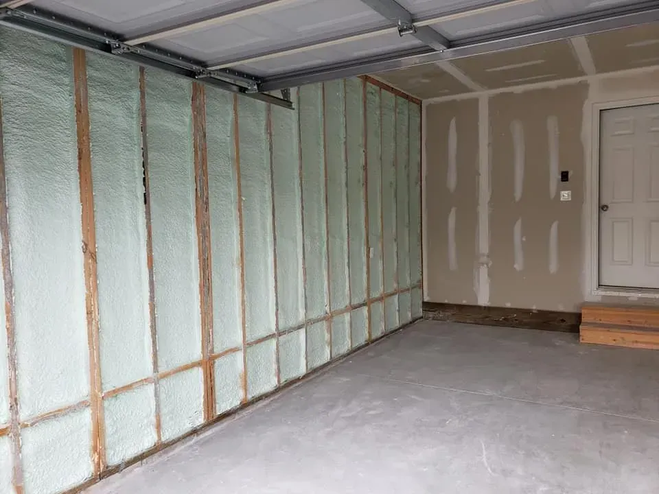 A garage with a lot of insulation on the walls and a door.