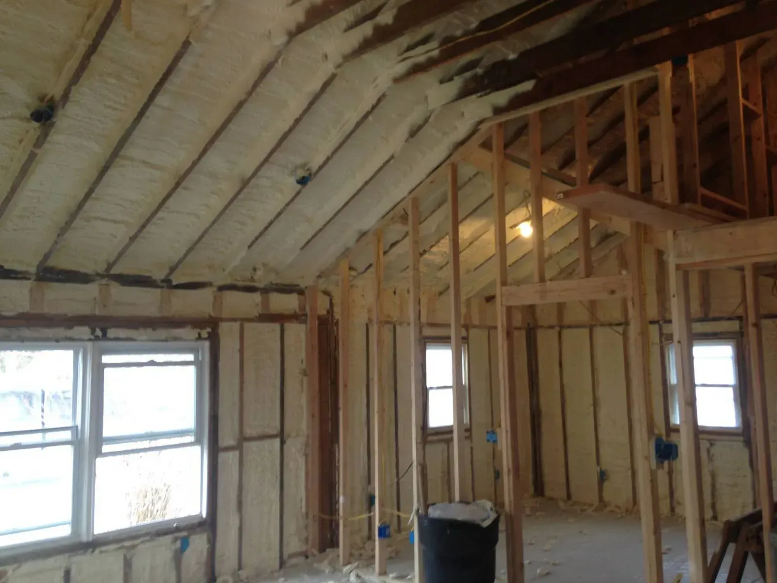 The ceiling of a house is being insulated with spray foam.