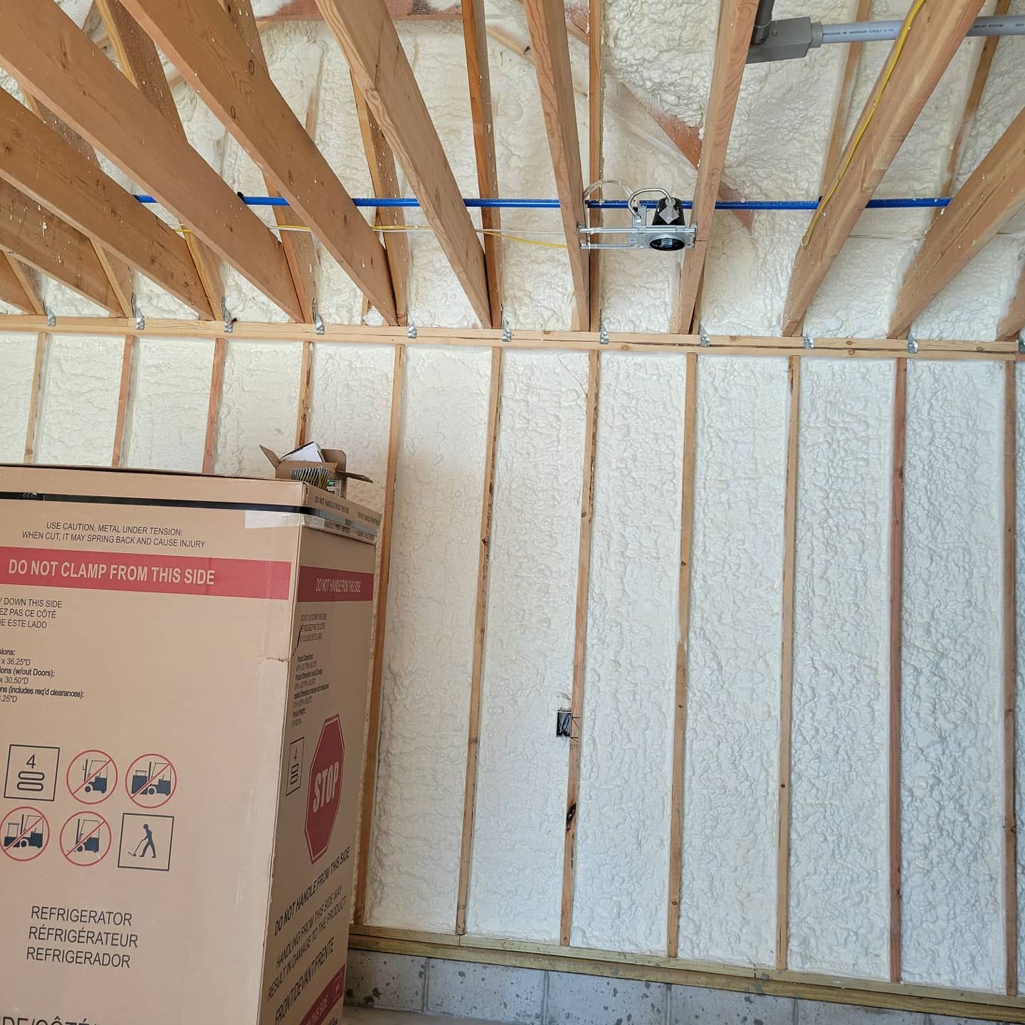 A cardboard box is sitting in the middle of a room with foam on the walls