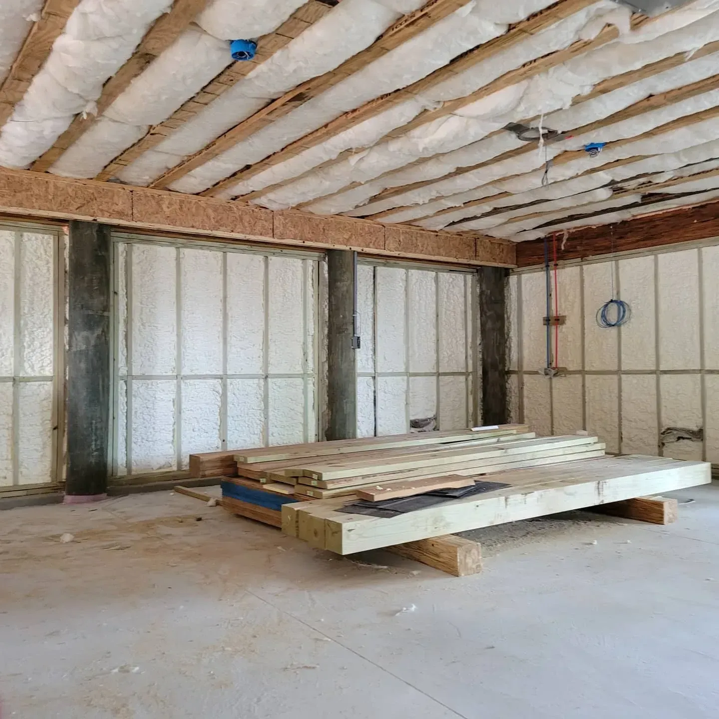 A room with a lot of wood and insulation on the ceiling.