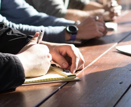 Person holding a pen and a paper