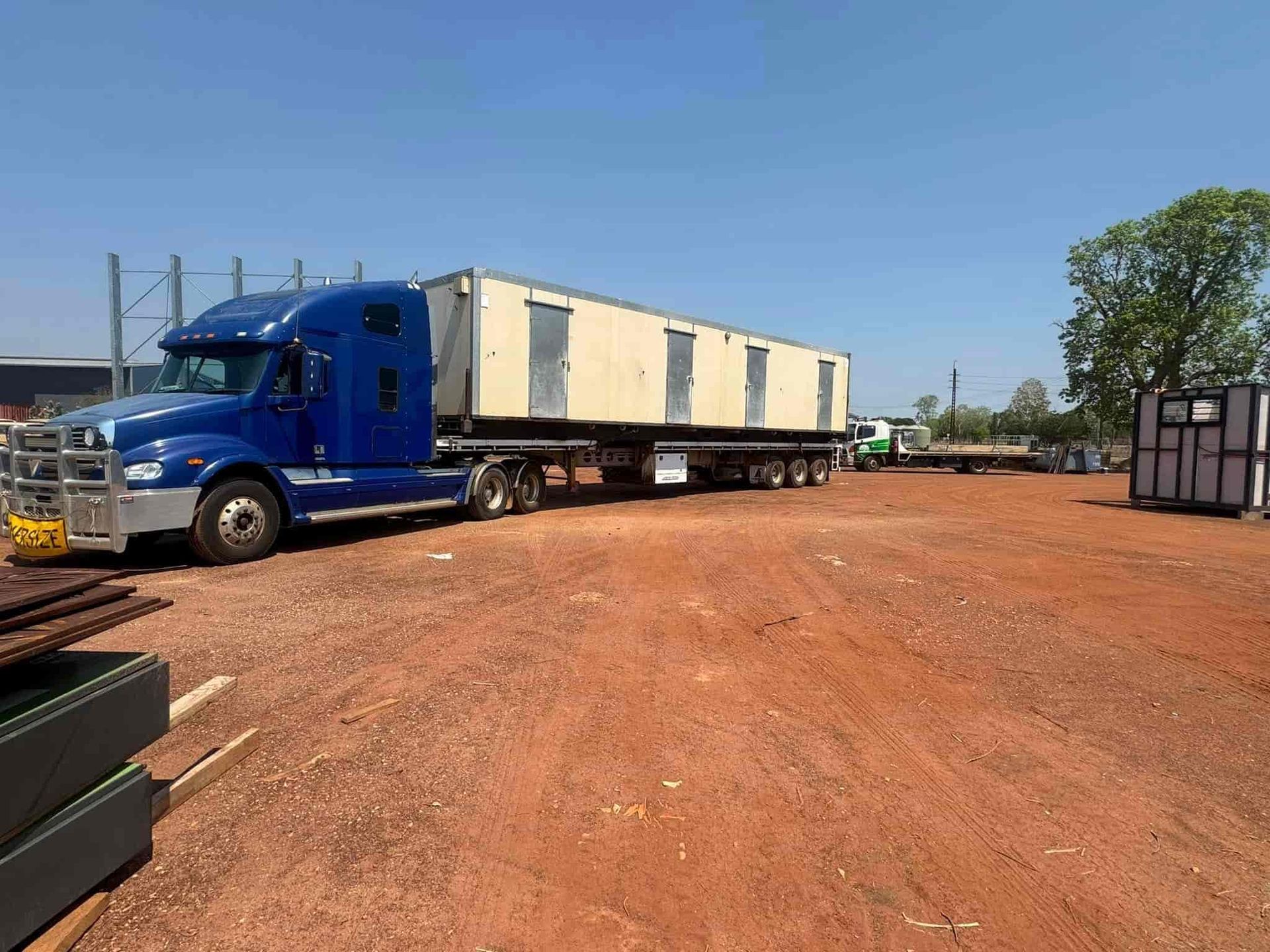 A Blue Semi Truck is Driving Down a Dirt Road — Cohen’s Towing & 4WD Recoveries In Winnellie, NT