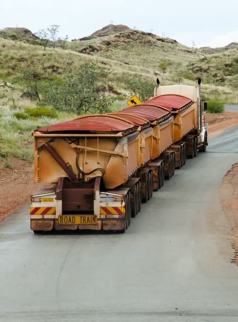A Large Semi Truck is Driving Down a Dirt Road — Cohen’s Towing & 4WD Recoveries In Winnellie, NT