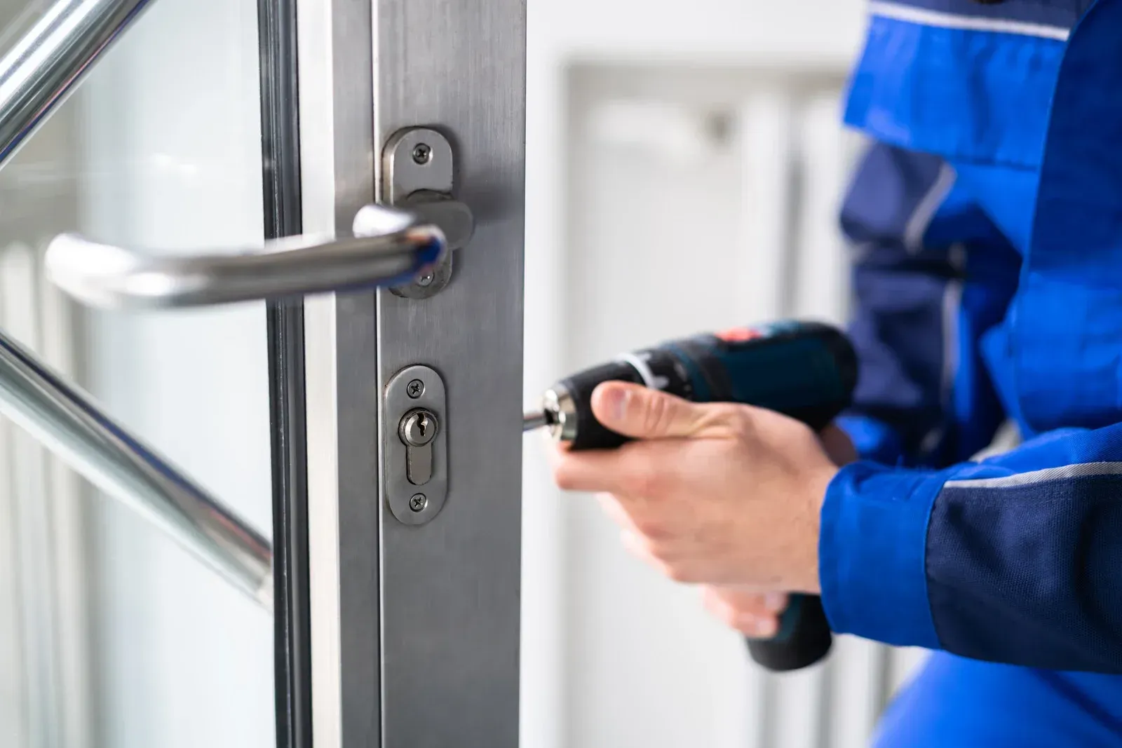 Person in blue uniform using a keyless device to unlock a glass door