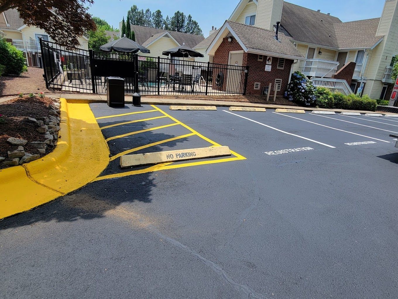 A parking lot with a yellow curb and yellow lines