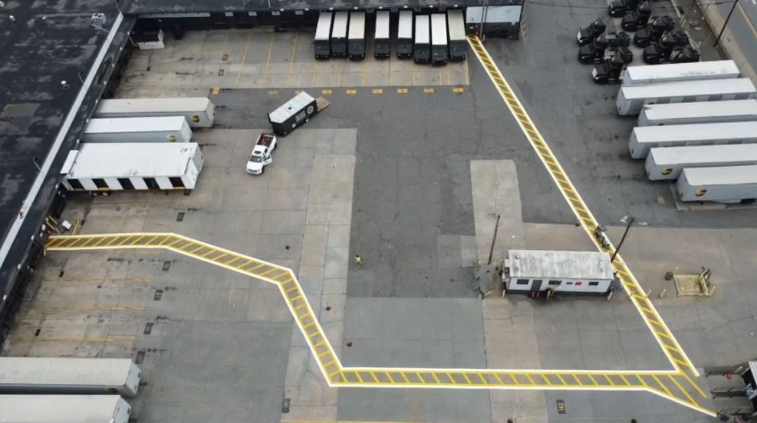 An aerial view of a warehouse with trucks parked in it