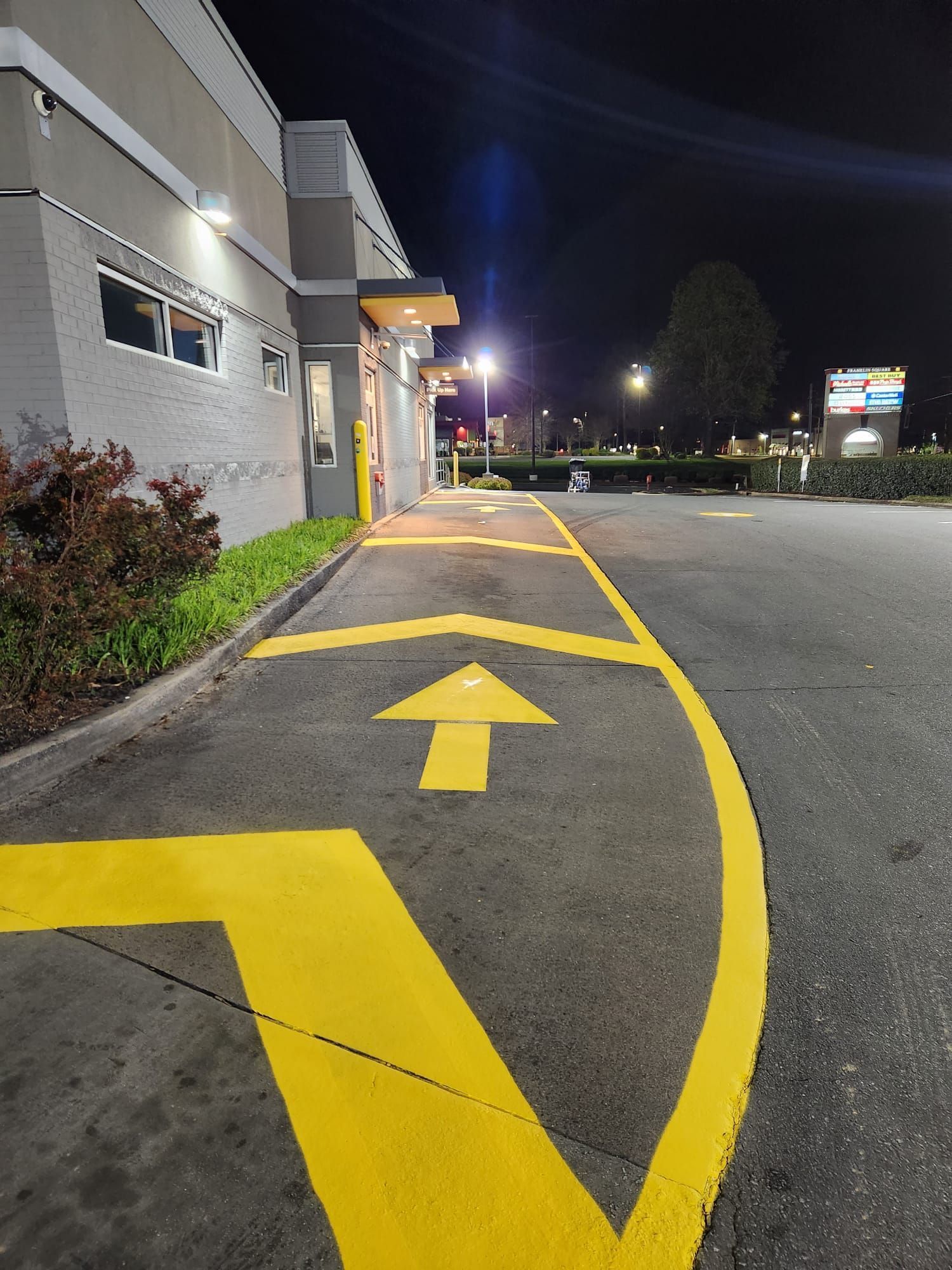 A parking lot with a yellow arrow pointing to the right