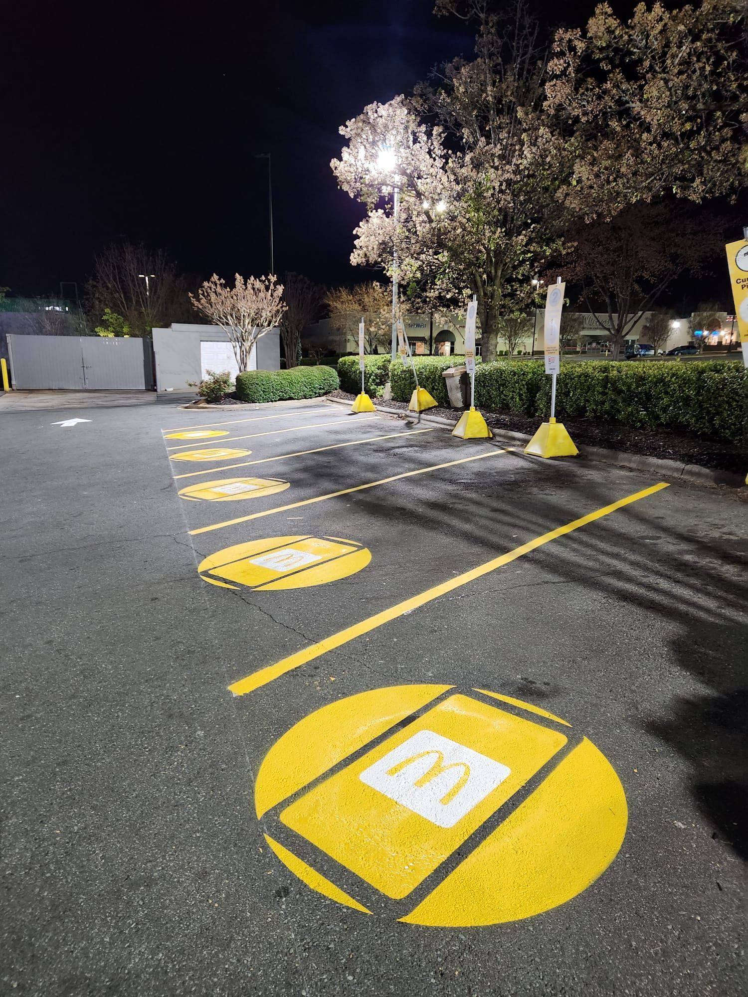 A parking lot with yellow circles painted on it at night.