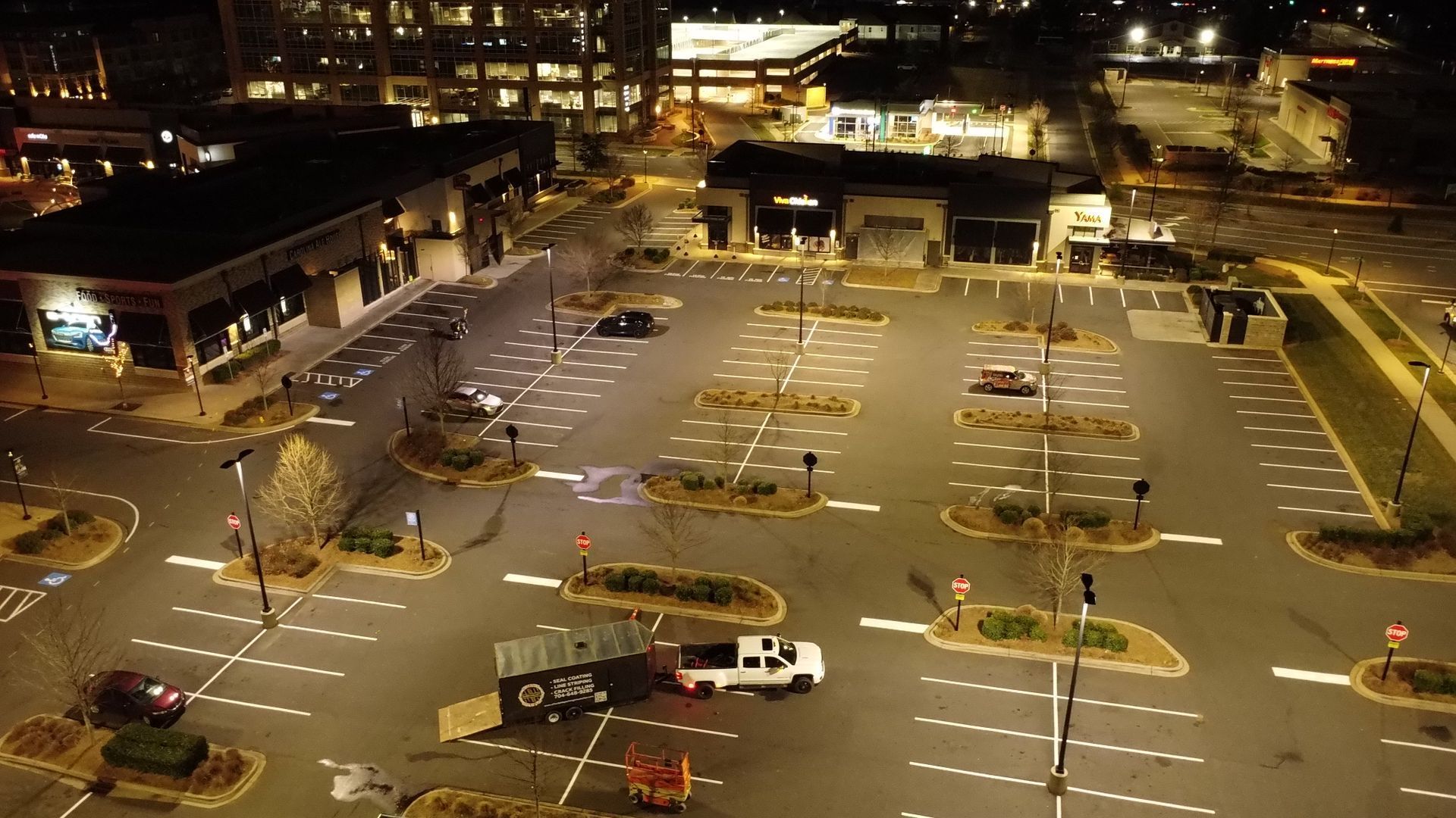 An aerial view of an empty parking lot at night.