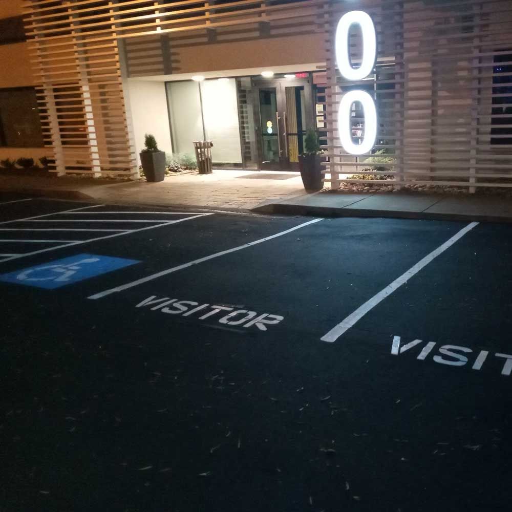 A parking lot with the words visitor and visit painted on it