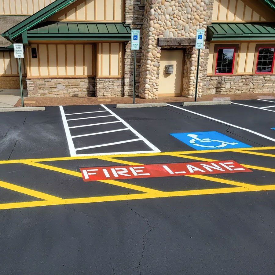 A fire lane is painted on the asphalt in front of a building