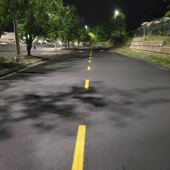 A road with a yellow line on it at night