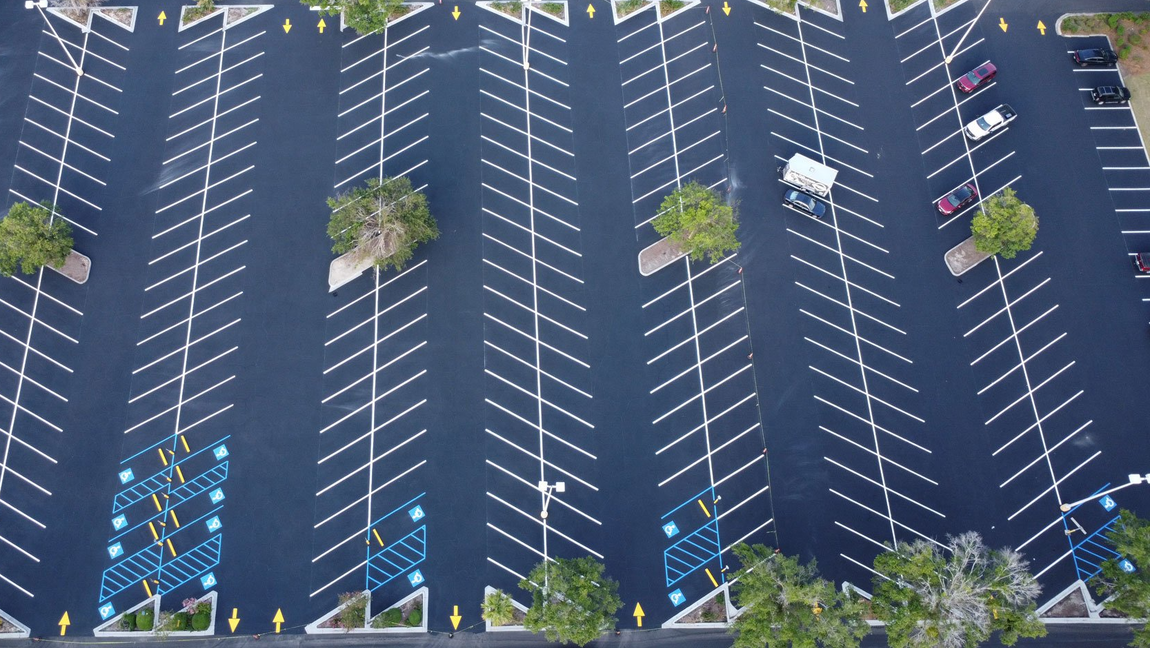 An aerial view of a parking lot with cars parked in it.