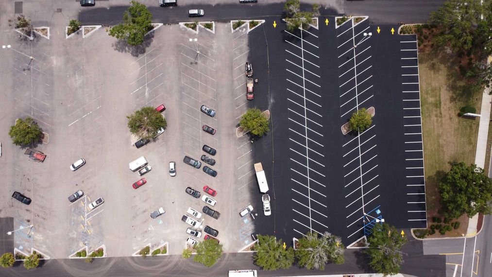 An aerial view of a parking lot with cars parked in it