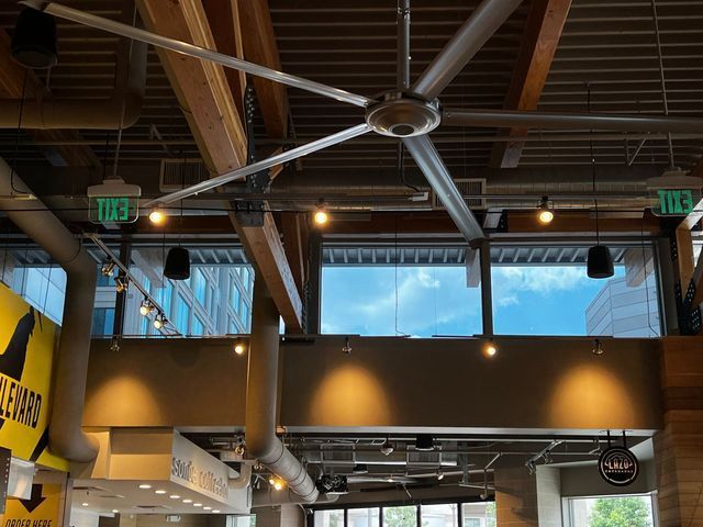 a large ceiling fan is hanging from the ceiling of a building .