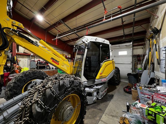A yellow and white tractor is parked in a garage